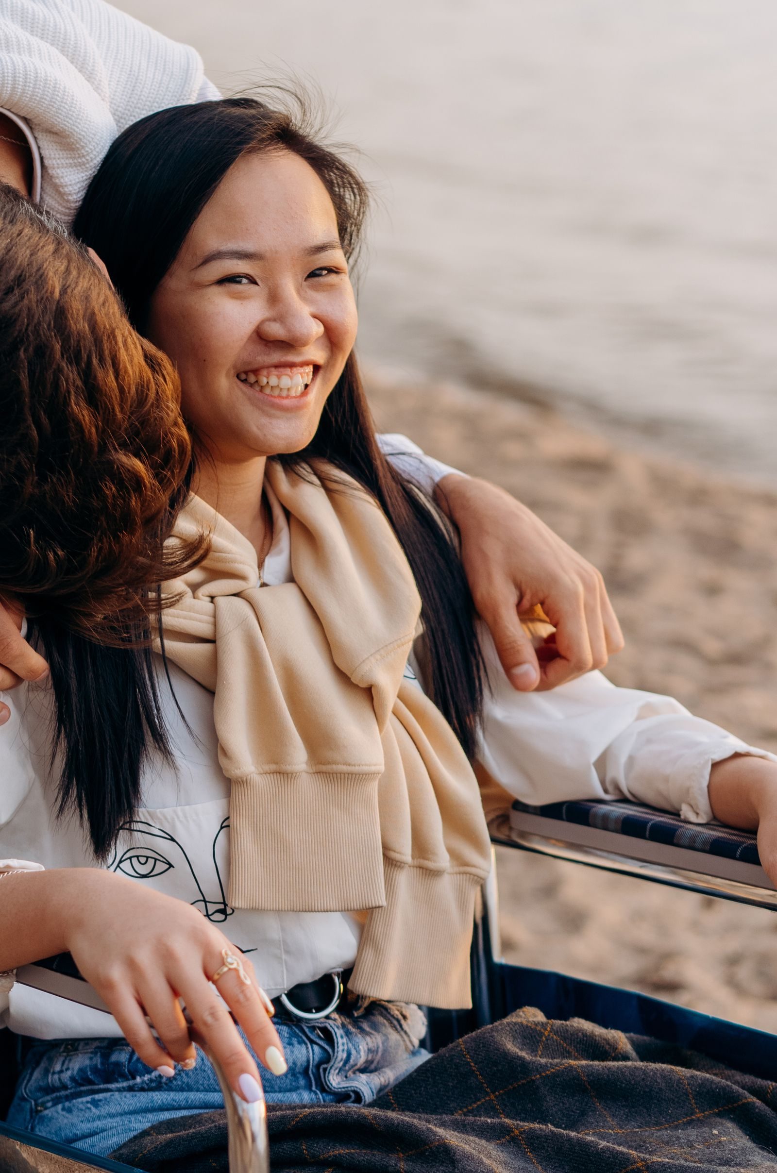 A happy woman in a wheelchair enjoying a day by the beach, radiating joy and warmth.
