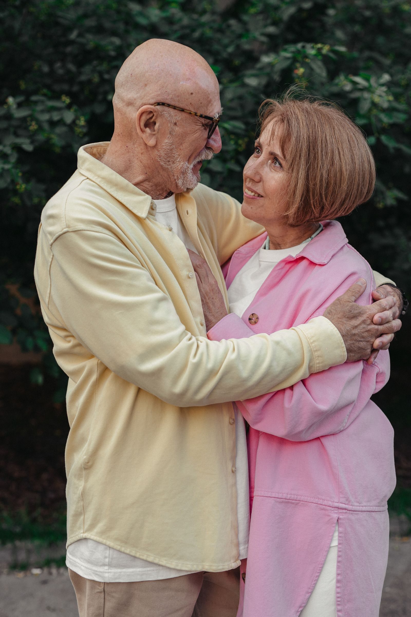 Senior couple sharing an affectionate embrace outdoors, expressing love.