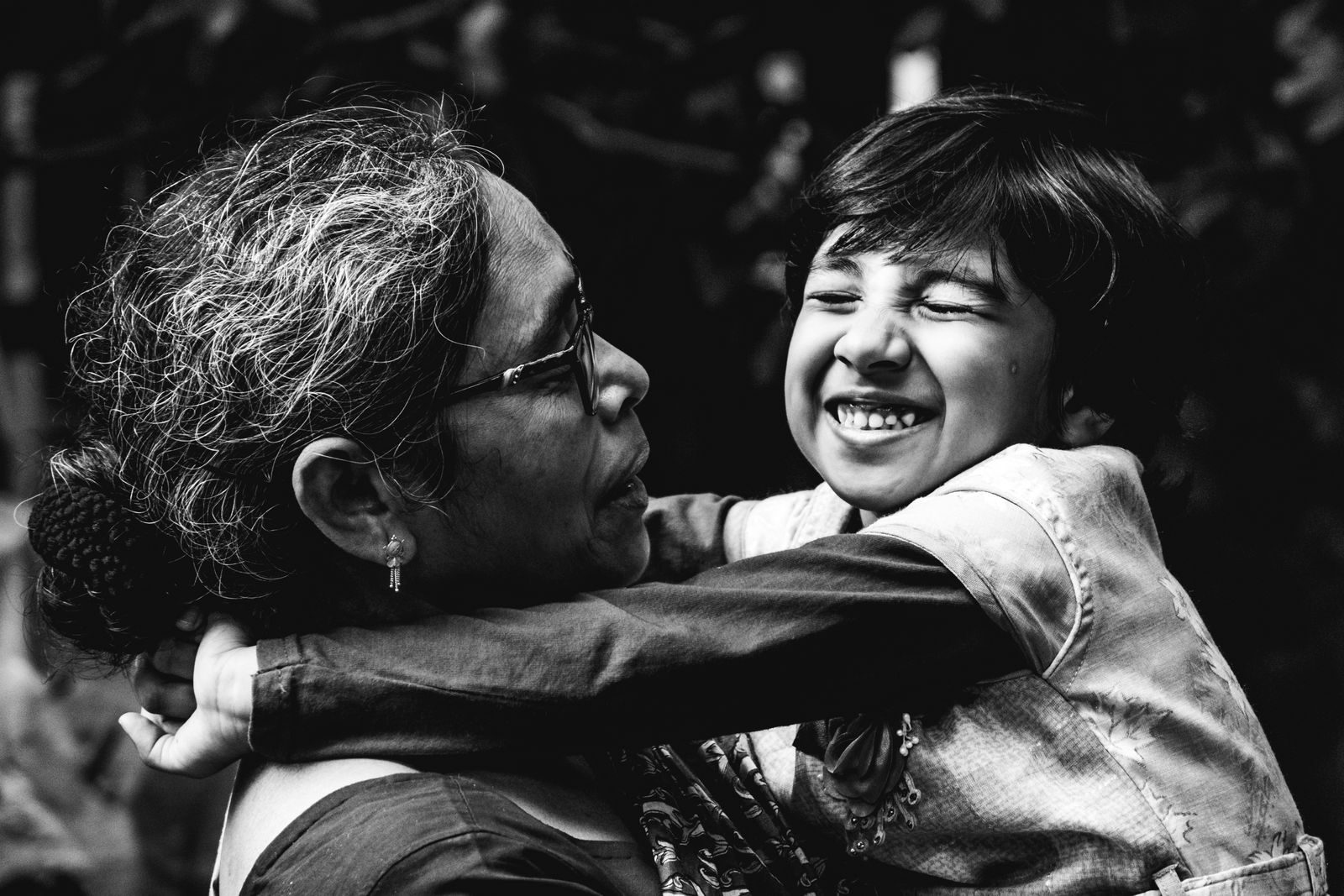 A joyful mother and son embrace each other with smiles and love.