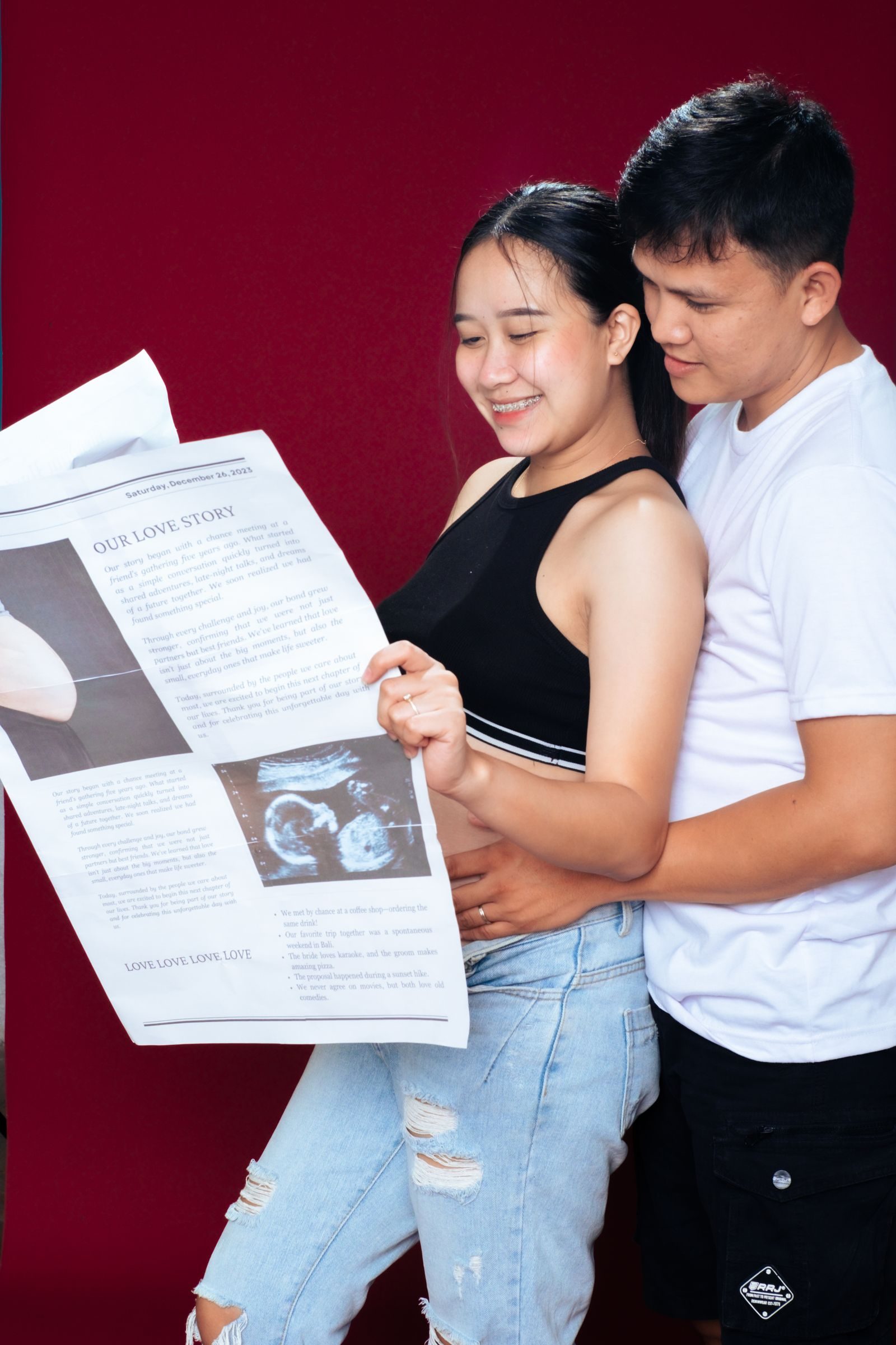 Happy couple joyfully reads pregnancy announcement together indoors.