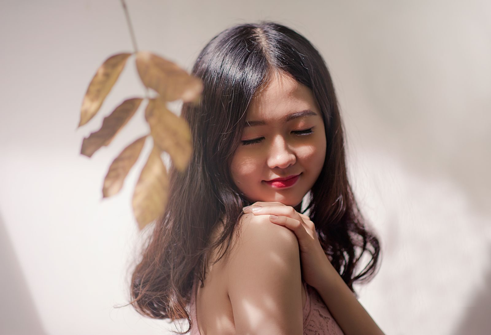 Peaceful young woman with eyes closed, embracing serenity with a gentle smile.