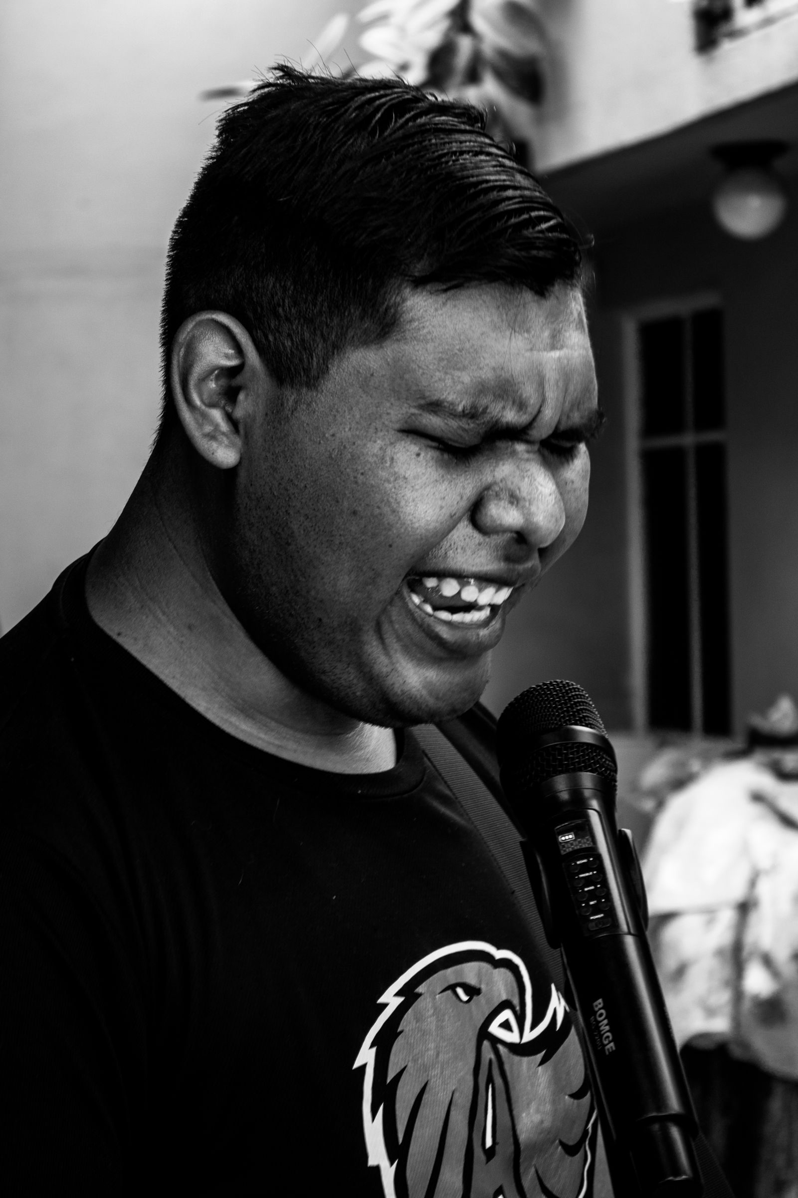 Dynamic black and white portrait of a singer passionately performing outdoors.
