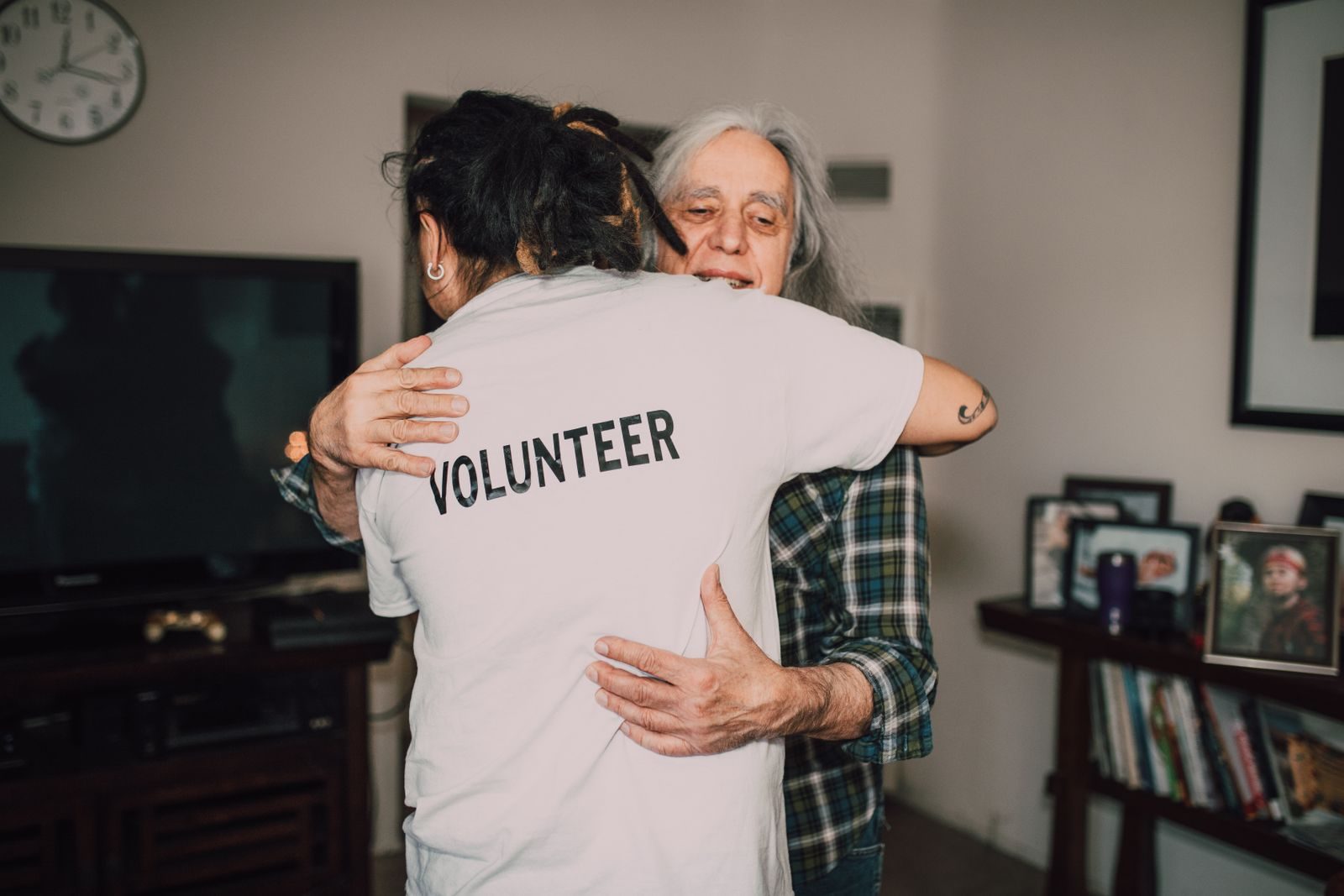 A volunteer embraces a senior woman in a heartfelt moment of support and love.
