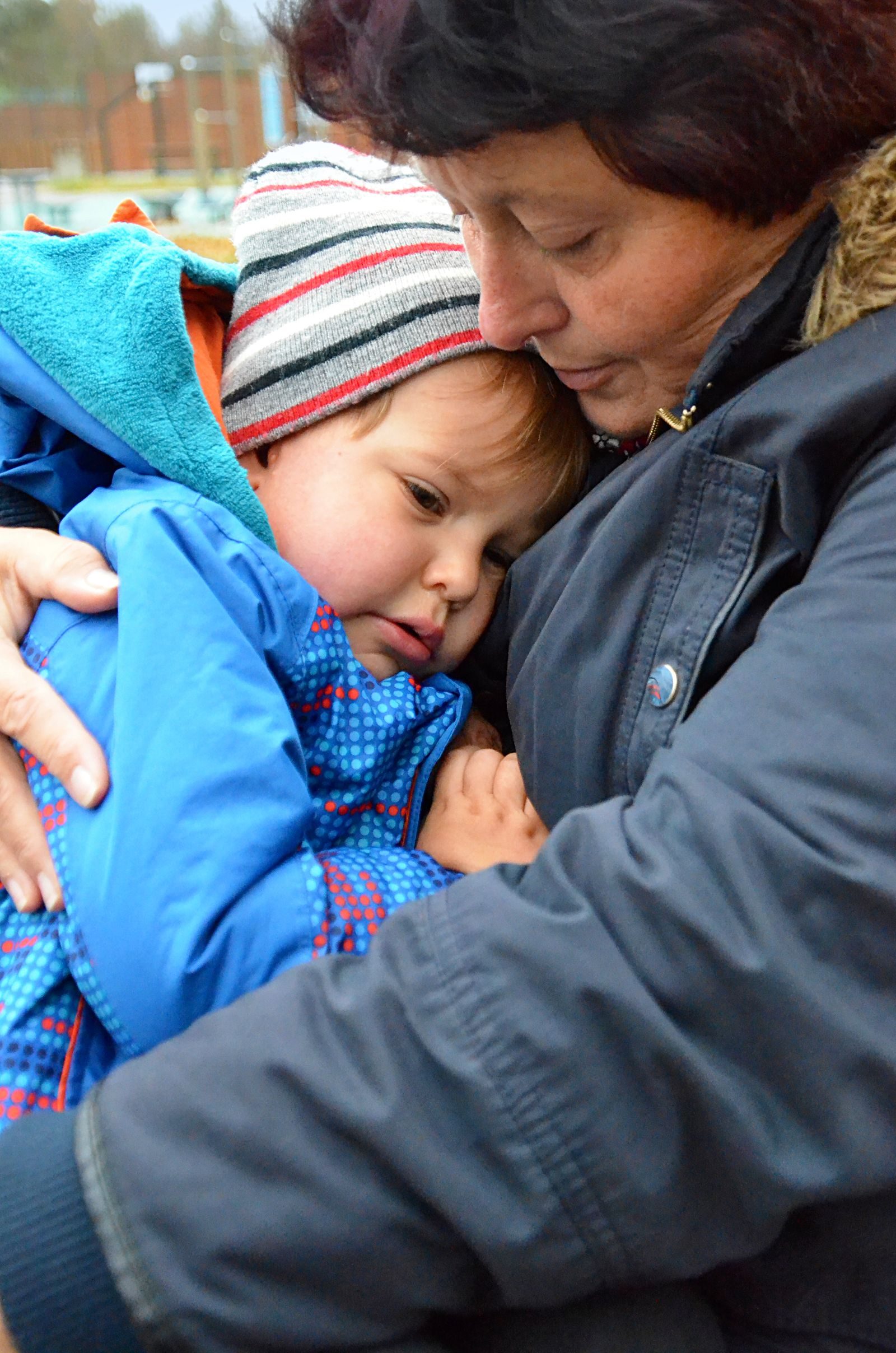 A tender moment of love and affection between a grandmother and her grandchild outdoors.