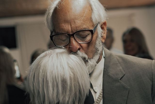 A senior couple sharing an emotional embrace at an indoor gathering.