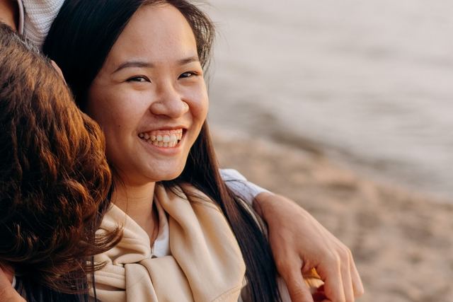 A happy woman in a wheelchair enjoying a day by the beach, radiating joy and warmth.