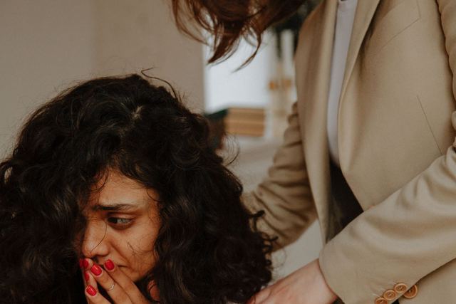 A young woman receiving comforting support in a counseling session.