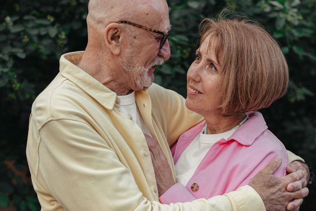 Senior couple sharing an affectionate embrace outdoors, expressing love.