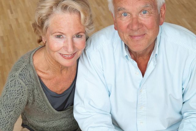 Happy senior couple using a laptop and calculator for financial planning.