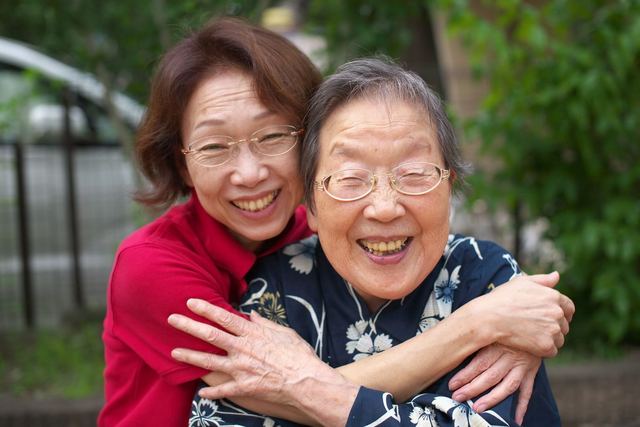 Happy mother and daughter embracing outside, showcasing love and joy.