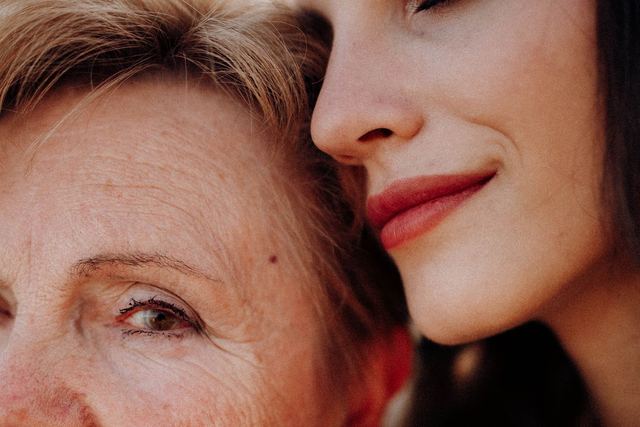 Close-up portrait of a mother and daughter sharing a quiet, intimate moment.