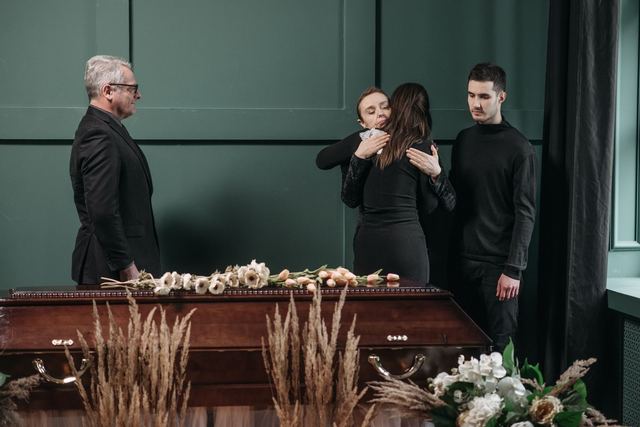 A heartfelt moment of comfort and empathy during a funeral service indoors.