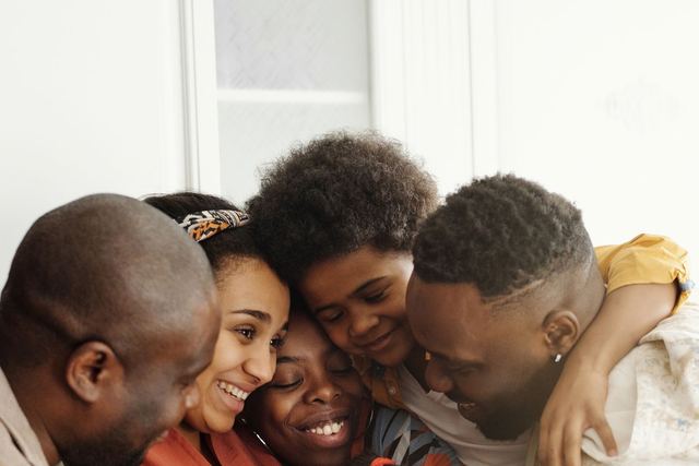 A joyful moment of family bonding captured in a warm embrace indoors.