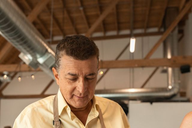 Senior man engaging in painting activity inside an artsy studio setting. Creative hobby vibe.